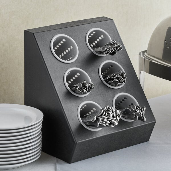 A gray plastic flatware organizer with holes for silverware in it.