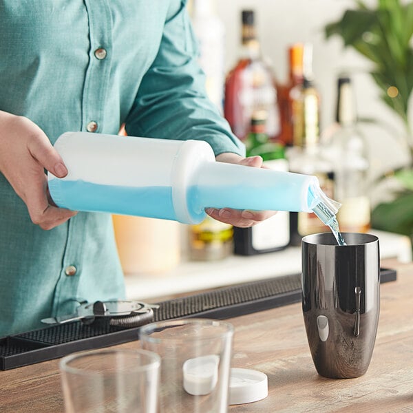 A person using a Choice pour bottle to pour liquid into a glass.