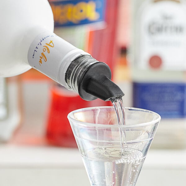 A person using a Choice black screened liquor pourer to pour clear liquid into a glass.