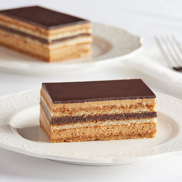 A slice of White Toque Opera Strip Cake on a white plate with a fork.