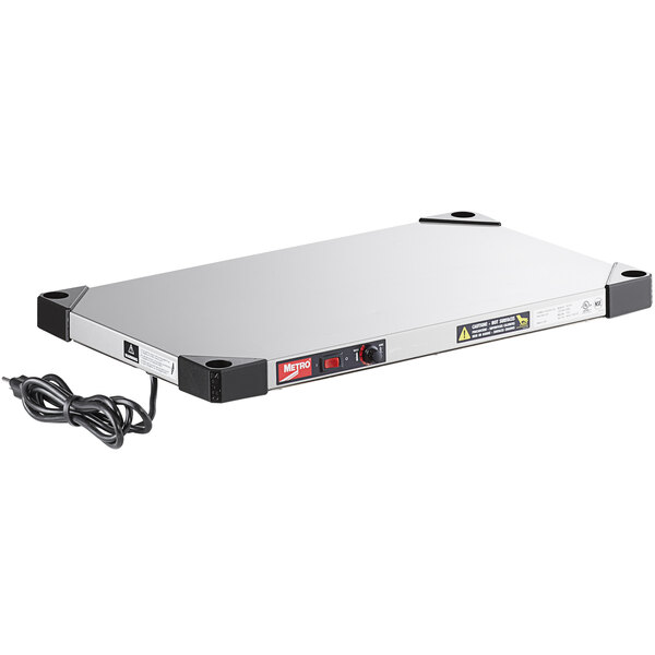 A rectangular silver Metro Super Erecta heated shelf with a black power cord.