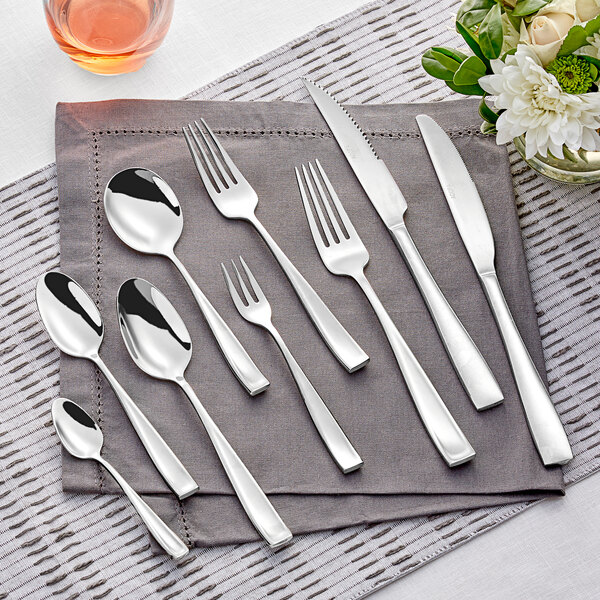 A stainless steel dinner fork and knife on a napkin.