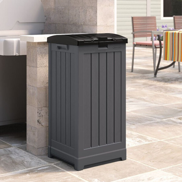 A grey Suncast Trash Hideaway on a patio.