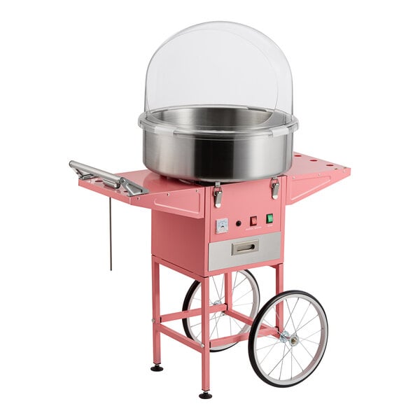A pink cotton candy machine with a stainless steel bowl, clear dome cover, and wheeled cart.