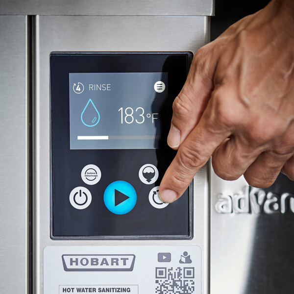 A close-up of a control panel on a Hobart high temperature door-style ventless tall base electric dishwasher with a booster heater, showing a hand pressing a button.