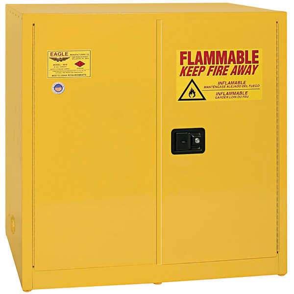 A yellow Eagle Manufacturing safety cabinet with a warning sign for flammable liquids.