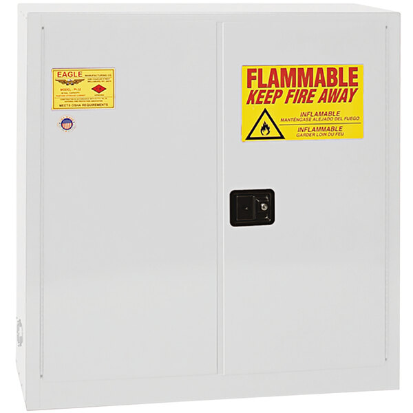 A white Eagle Manufacturing safety cabinet with a yellow sign reading "Flammable"