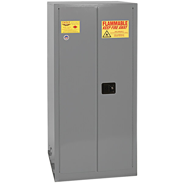 A grey metal Eagle Manufacturing safety cabinet with yellow labels.