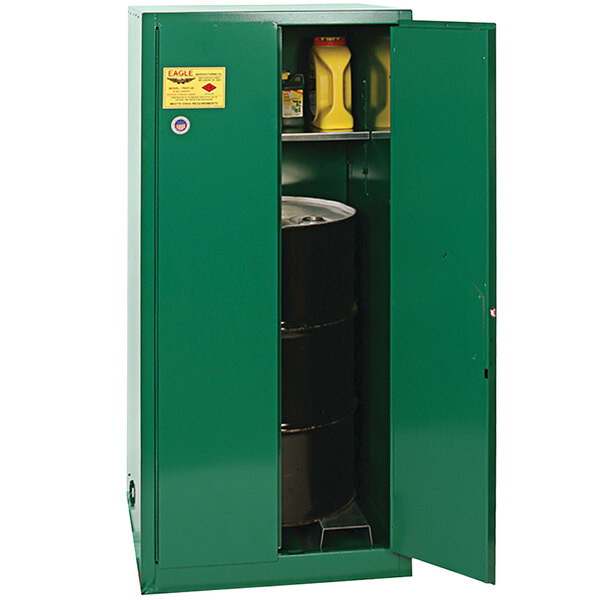 A green metal Eagle Manufacturing pesticide safety cabinet with a barrel inside.