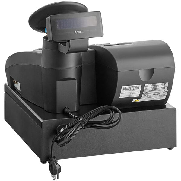 A black Royal Alpha electronic cash register on a counter with a cord attached.