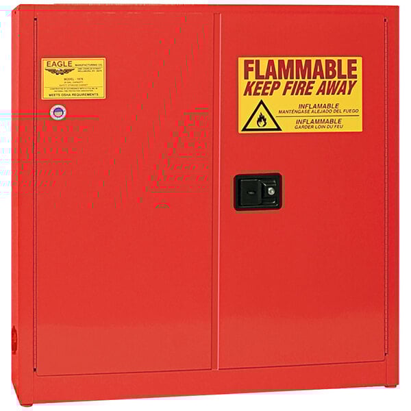 A red Eagle Manufacturing safety cabinet for flammable liquids with yellow and red warning signs.