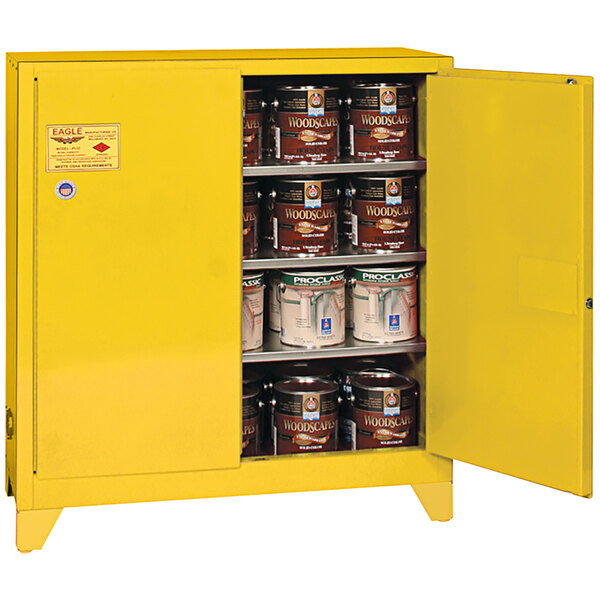 A yellow Eagle Manufacturing safety cabinet storing paint cans.