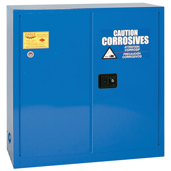 A blue metal Eagle Manufacturing safety cabinet with white text warning of acid and corrosion.