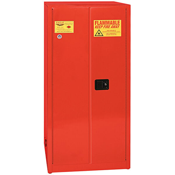 A red metal Eagle safety cabinet with a yellow and red warning sign and keyhole.