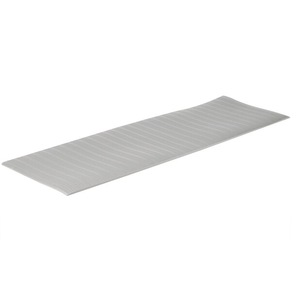 A grey ribbed vinyl anti-fatigue mat with curved edges and a striped pattern.