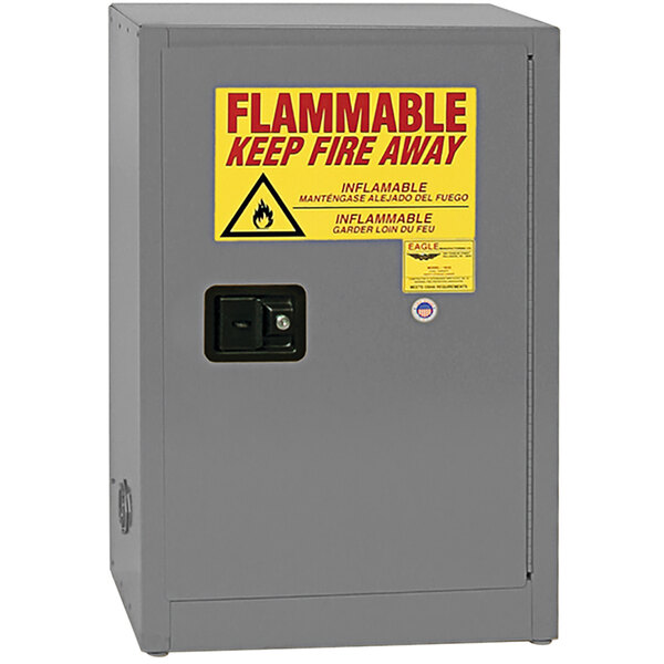 A grey metal Eagle Manufacturing safety cabinet with a yellow flammable liquid sign.