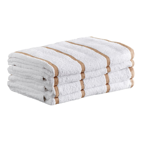 A stack of four white towels with beige stripes.