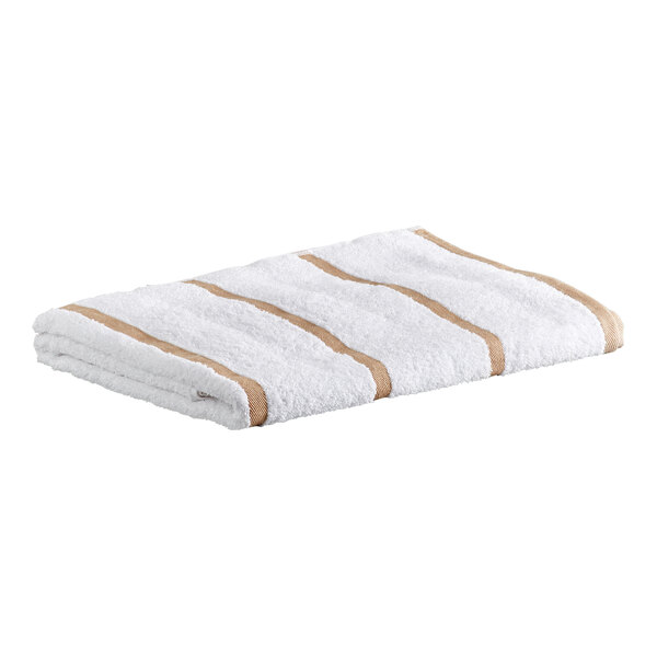A folded white towel with beige stripes lying on a flat surface.
