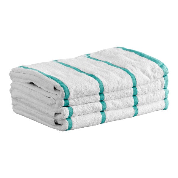 A stack of four white towels with green stripes.