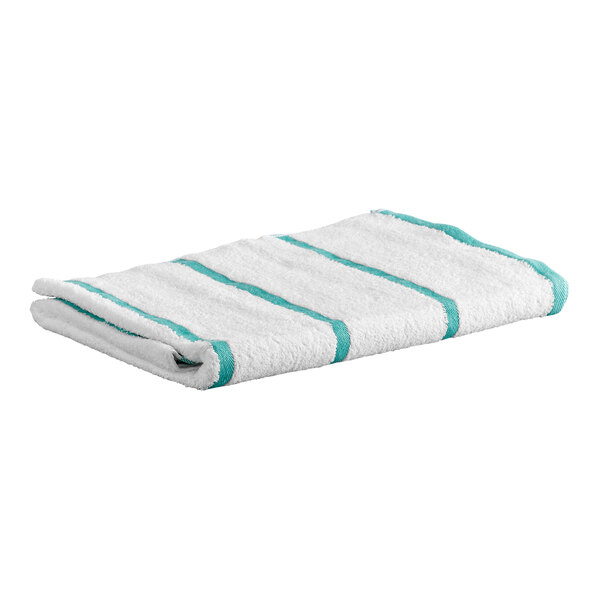 A folded white towel with green stripes lying on a flat surface.