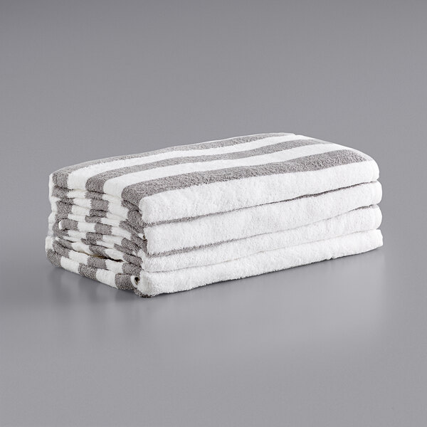 A stack of Monarch Brands white and gray striped pool towels.