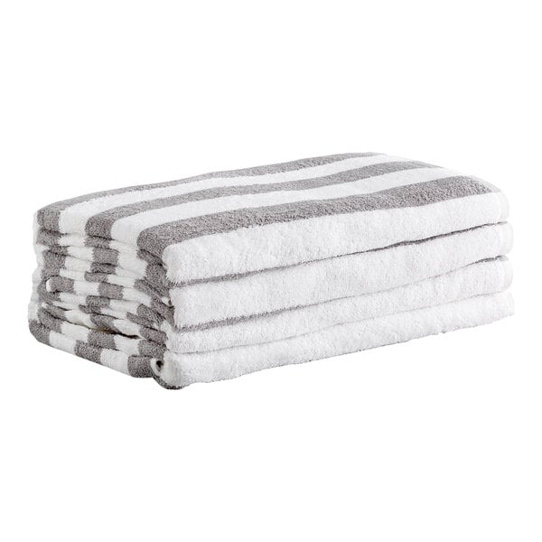 A stack of four white towels with gray stripes, neatly folded.
