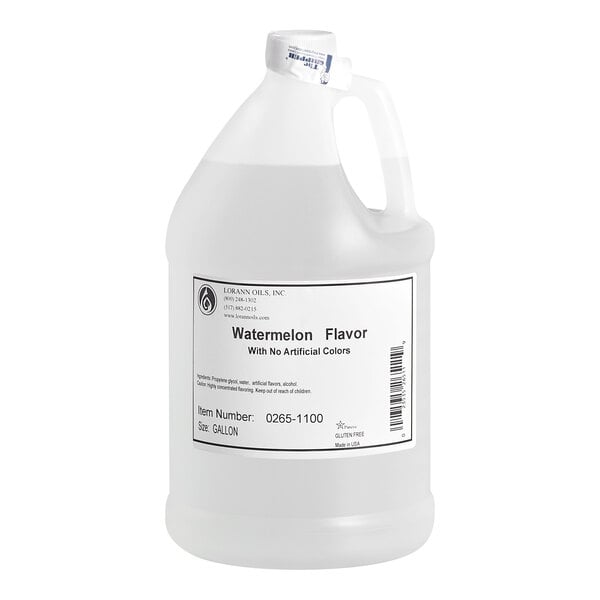 A large, clear plastic jug with a handle and a white label indicating it contains watermelon flavor with no artificial colors.