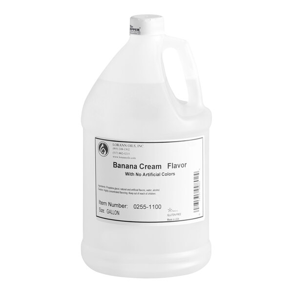 A large white plastic gallon jug with a handle and a label indicating it contains banana cream flavor with no artificial colors.
