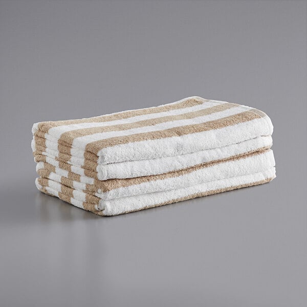 A stack of Monarch Brands pool towels with beige stripes.