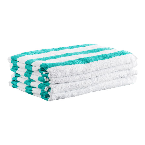 A stack of four white towels with green stripes.