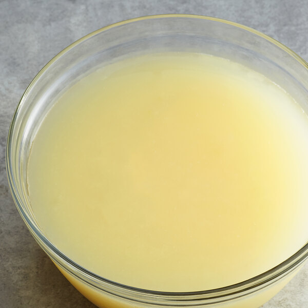 A bowl of Les Vergers Boiron Lemon Fruit Puree on a yellow surface.