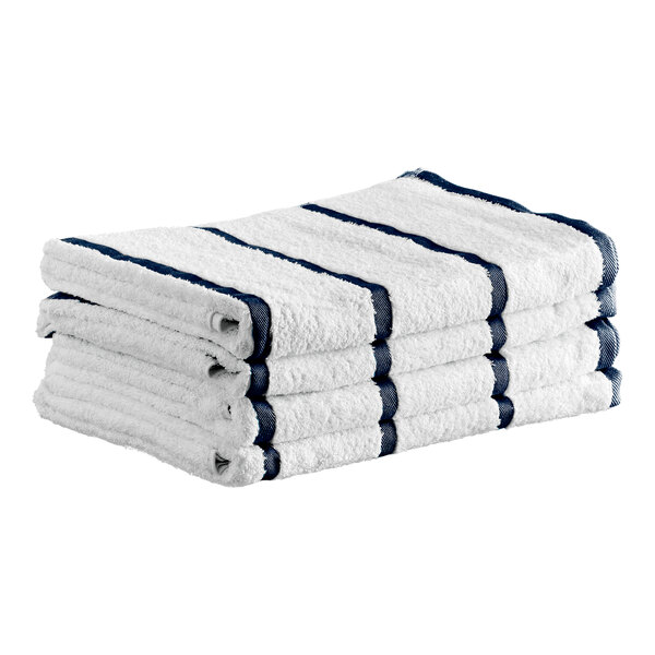A stack of four white towels with navy blue stripes.