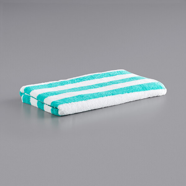 A green and white striped Monarch Brands pool towel.