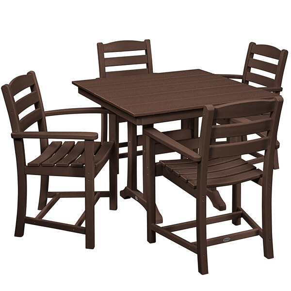 A POLYWOOD mahogany dining set with four arm chairs around a trestle table on an outdoor patio.