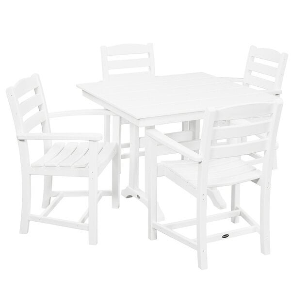 A POLYWOOD white farmhouse dining table with four arm chairs.