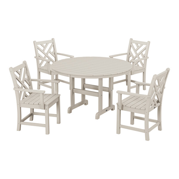 A white POLYWOOD table with four arm chairs around it.