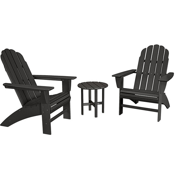 A group of three black POLYWOOD Curveback Adirondack chairs and a round table on an outdoor patio.