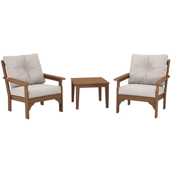 A brown square table with legs and two POLYWOOD Vineyard chairs with cushions on either side.
