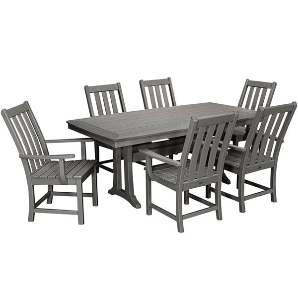 A POLYWOOD slate grey dining table with six chairs on an outdoor patio.