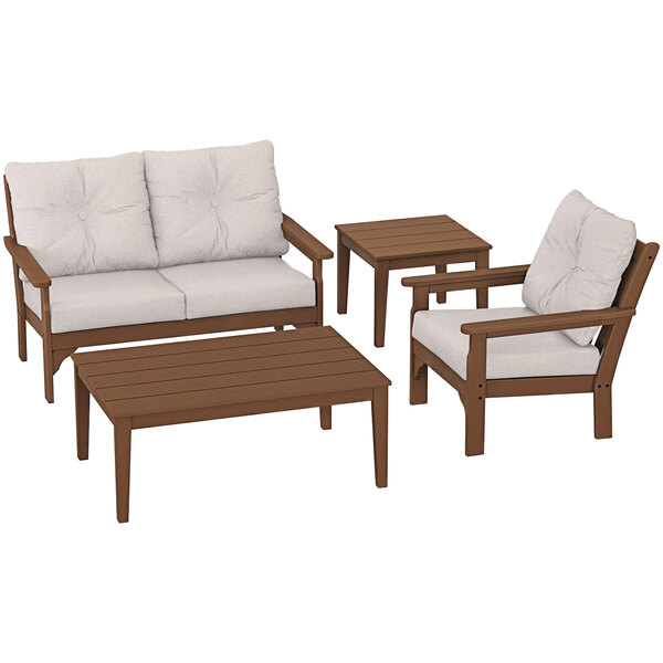 A wooden table and chairs with white cushions.