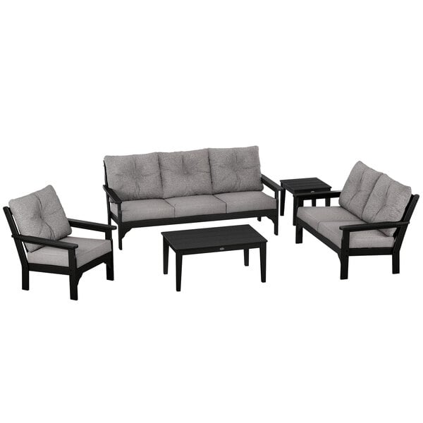 A black and grey POLYWOOD outdoor patio set with a couch and table.