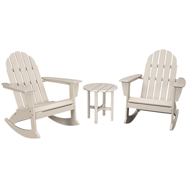 A white POLYWOOD round table with legs and 2 Adirondack rocking chairs with armrests.
