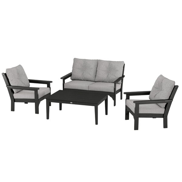 A black POLYWOOD table with grey cushions on a chair.