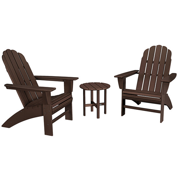 A brown POLYWOOD round table with legs and 2 brown Curveback Adirondack chairs.