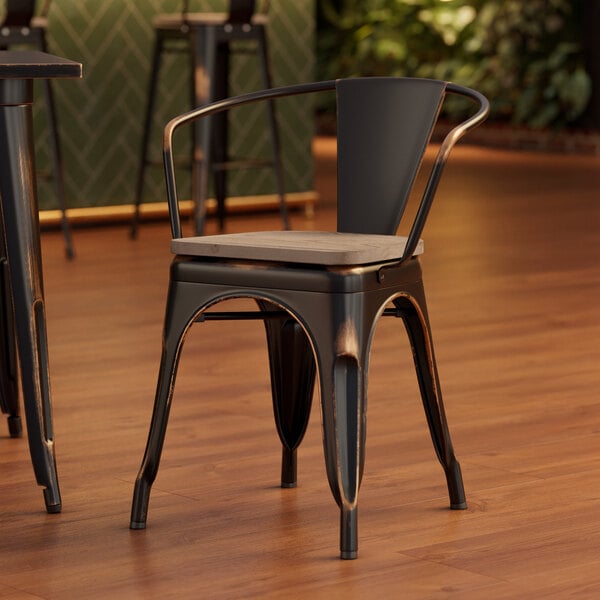 A Lancaster Table & Seating black metal chair with a wood seat.