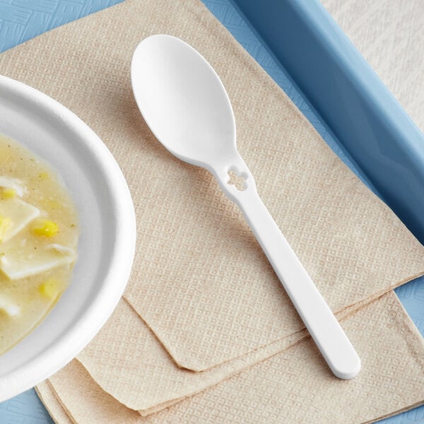 A white plastic spoon on a napkin.