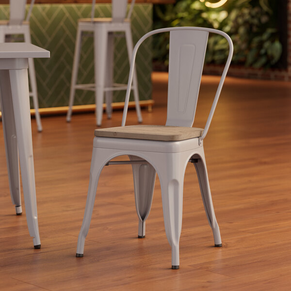 A Lancaster Table & Seating white metal chair with a gray wood seat.