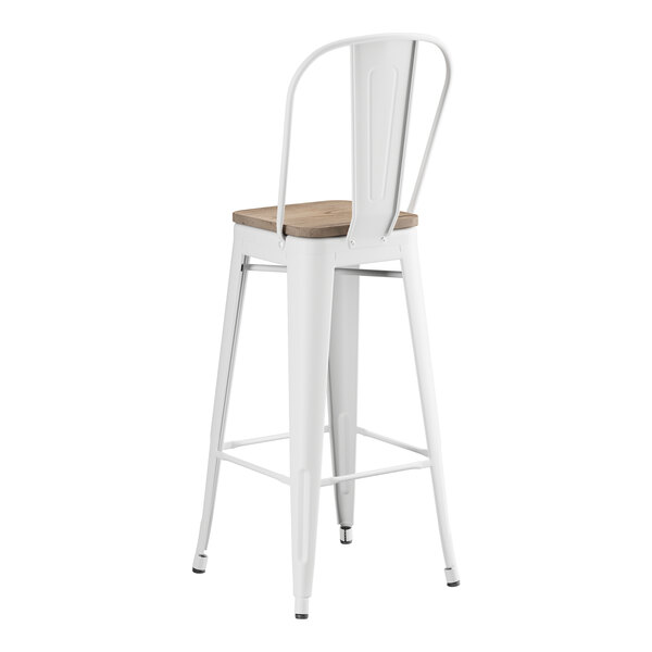 A white Lancaster Table & Seating bar stool with a gray wood seat.