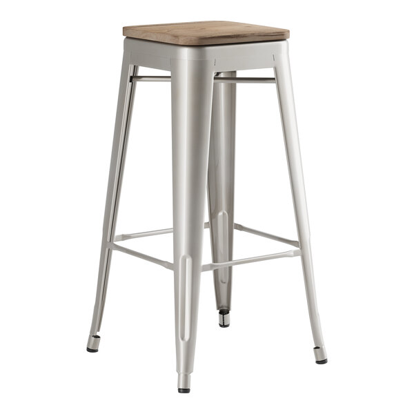 A Lancaster Table & Seating metal barstool with a gray wood seat.