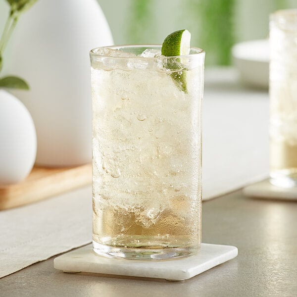 Two Acopa Pangea beverage glasses filled with iced tea, lime, and mint on a white background.